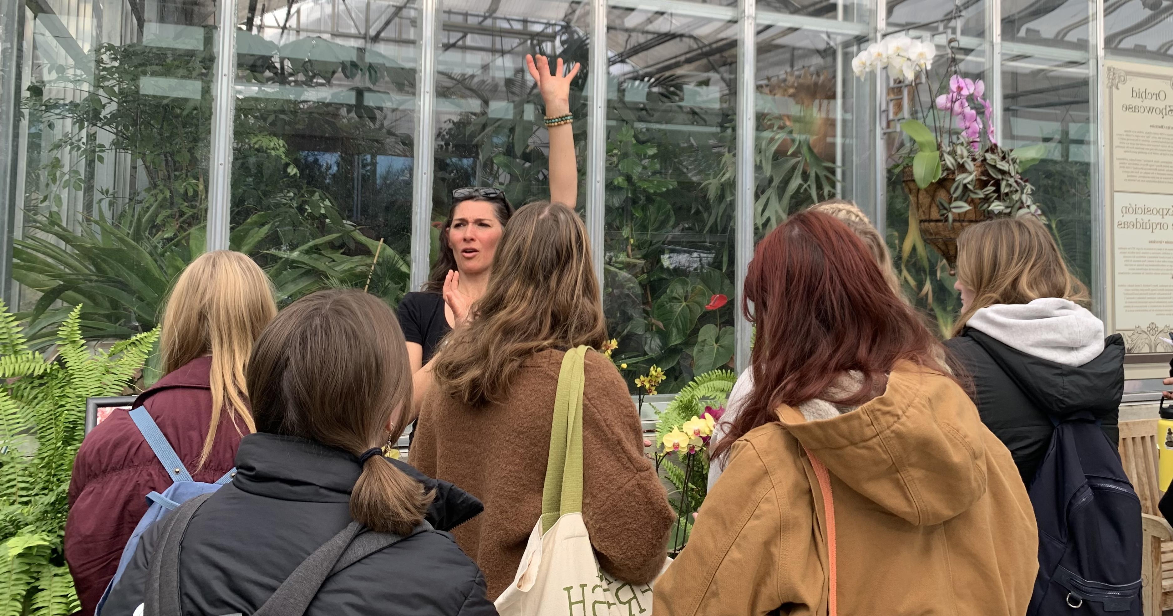 Roxaneh Khorsand教授带领学生到丹佛植物园第五街区的植物生物学实地考察，解释兰花的结构.